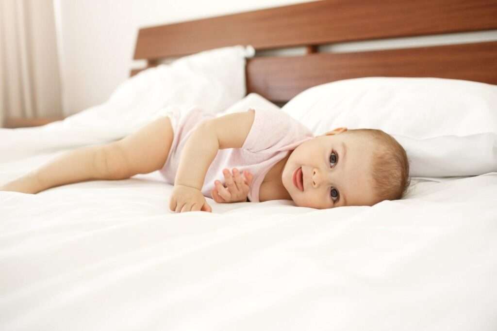 portrait beautiful cute newborn baby showing tongue lying bed home 1